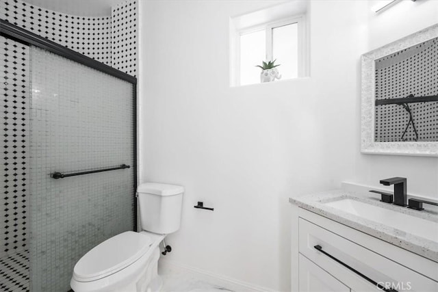 bathroom with a shower with shower door, toilet, and vanity