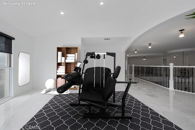 exercise room featuring arched walkways, visible vents, lofted ceiling, and recessed lighting