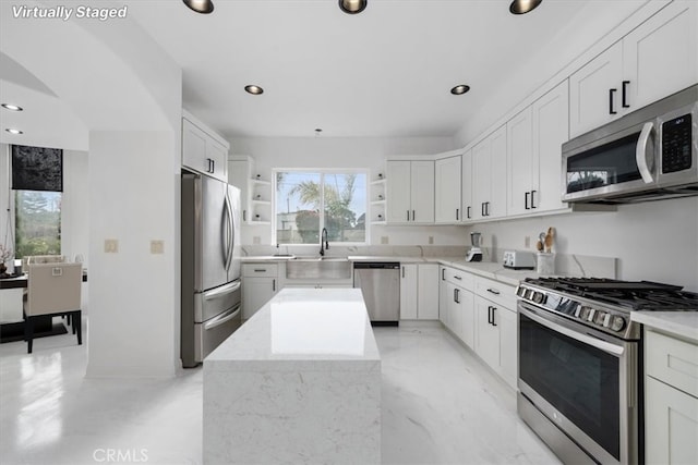 kitchen featuring white cabinets, a center island, stainless steel appliances, open shelves, and recessed lighting