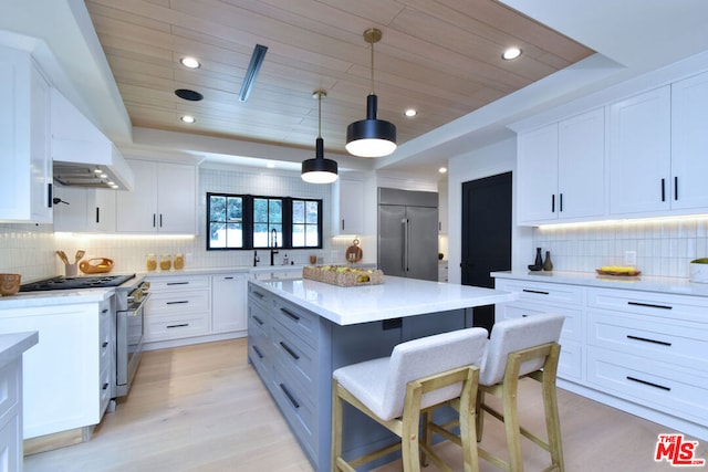 kitchen featuring premium appliances, wooden ceiling, white cabinets, hanging light fixtures, and light hardwood / wood-style flooring