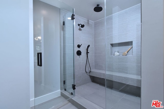 bathroom with an enclosed shower and tile patterned flooring