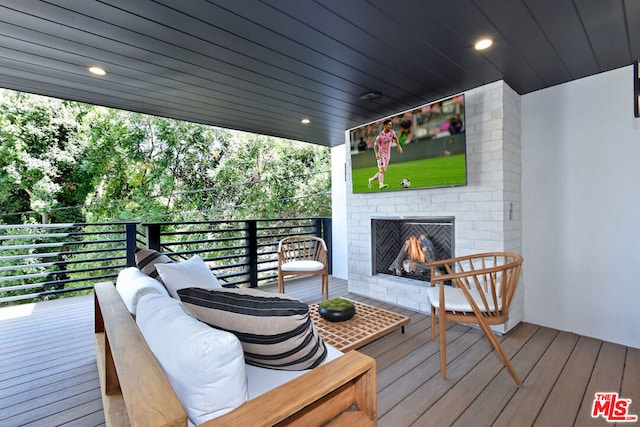 wooden deck featuring an outdoor living space with a fireplace