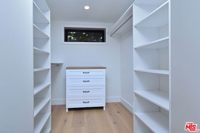 walk in closet with light hardwood / wood-style flooring