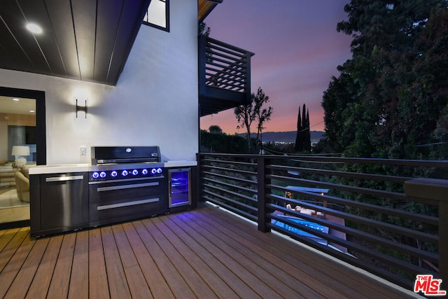 deck at dusk featuring area for grilling