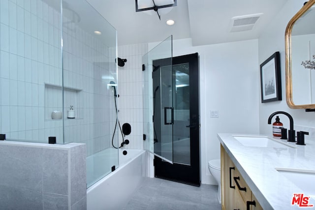 full bathroom featuring combined bath / shower with glass door, vanity, tile patterned floors, and toilet