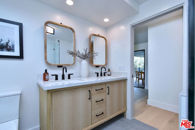 bathroom with hardwood / wood-style floors, toilet, and vanity