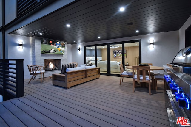 deck featuring an outdoor living space with a fireplace