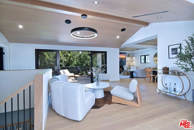 living room with vaulted ceiling with beams, a healthy amount of sunlight, wood ceiling, and light wood-type flooring