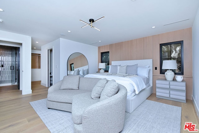 bedroom with light hardwood / wood-style flooring and a chandelier