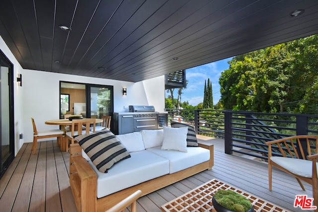 wooden terrace featuring an outdoor living space and grilling area