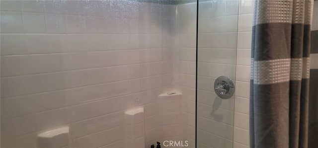 interior details featuring a tile shower