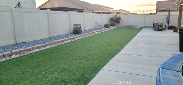 yard at dusk featuring a patio