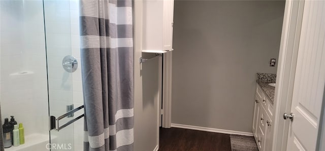 bathroom with walk in shower, vanity, and hardwood / wood-style floors