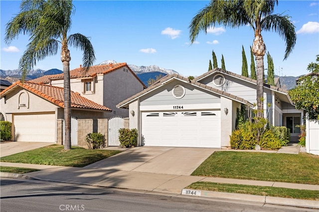 view of front of house with a mountain view, a front yard, and a garage