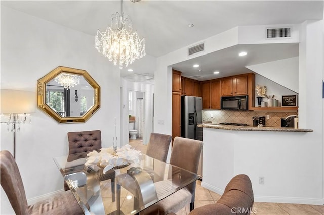 dining area featuring light tile patterned floors and a notable chandelier