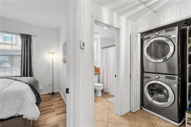 clothes washing area featuring stacked washer / dryer and light tile patterned floors