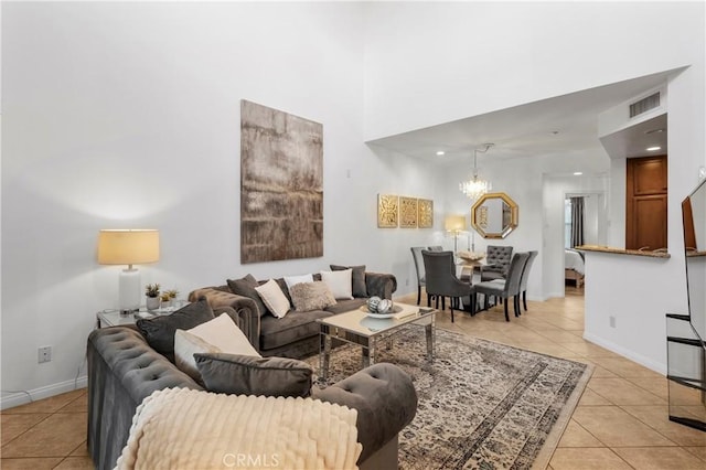 living room with an inviting chandelier, light tile patterned floors, and a towering ceiling