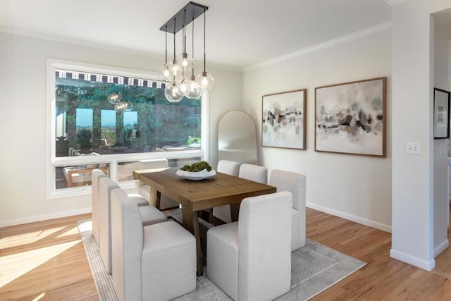 dining room with ornamental molding, a healthy amount of sunlight, a chandelier, and light hardwood / wood-style flooring