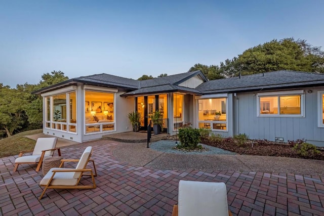 rear view of house with a patio area and a sunroom