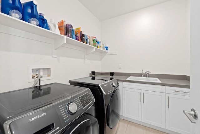 clothes washing area featuring sink, cabinets, washer and dryer, and light tile patterned flooring