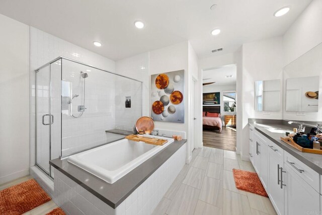 bathroom featuring vanity, shower with separate bathtub, and tile patterned floors