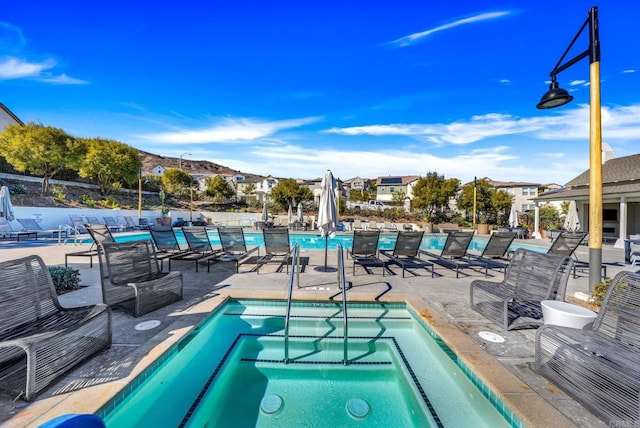 view of pool featuring a community hot tub and a patio