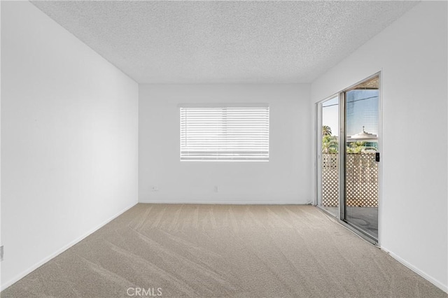 carpeted spare room with a textured ceiling