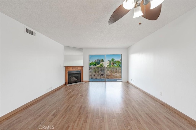 unfurnished living room with ceiling fan, a textured ceiling, and light wood-type flooring