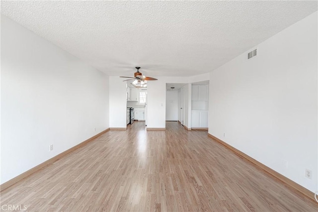 unfurnished living room with a textured ceiling, ceiling fan, and light wood-type flooring