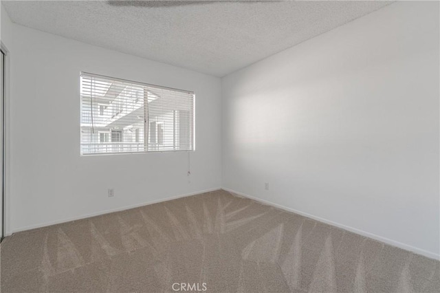 unfurnished room featuring a textured ceiling and carpet flooring