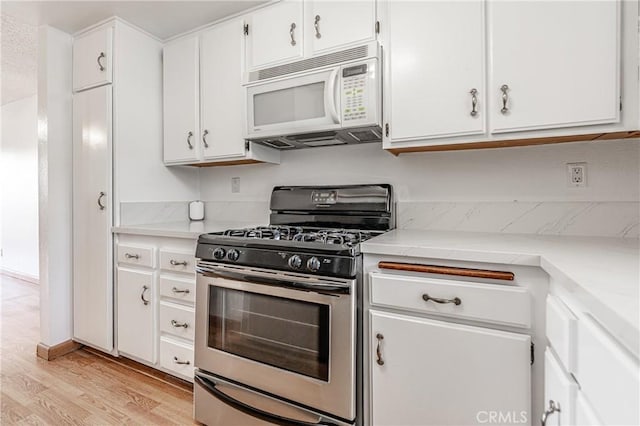 kitchen with light hardwood / wood-style floors, white cabinets, and stainless steel range with gas stovetop