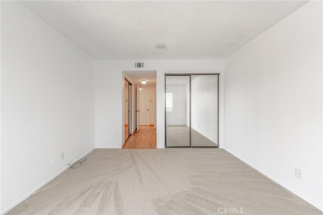 955 E 3rd St Unit 304, Long Beach, CA 90802 - unfurnished bedroom featuring carpet, a closet, a textured ceiling, and baseboards