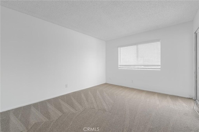 unfurnished room with baseboards, carpet flooring, and a textured ceiling