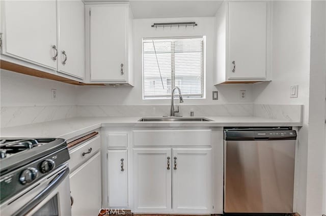 kitchen with stainless steel appliances, white cabinetry, and sink