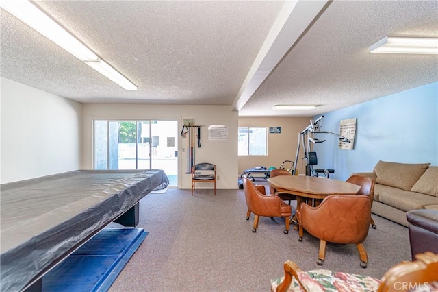 game room featuring a textured ceiling, pool table, a wealth of natural light, and carpet flooring