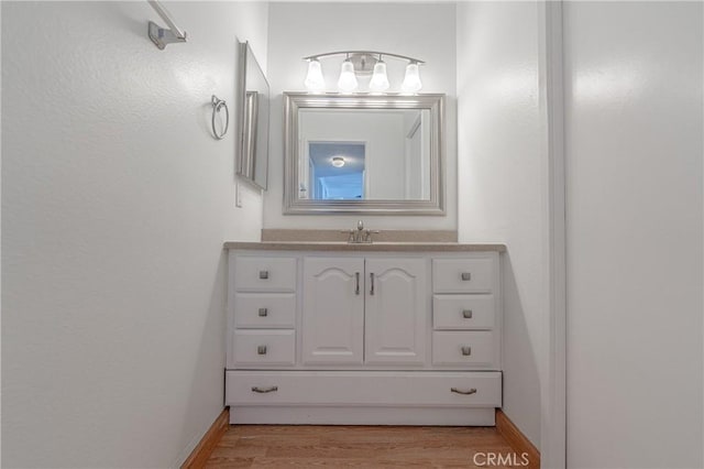 bathroom with wood finished floors and vanity
