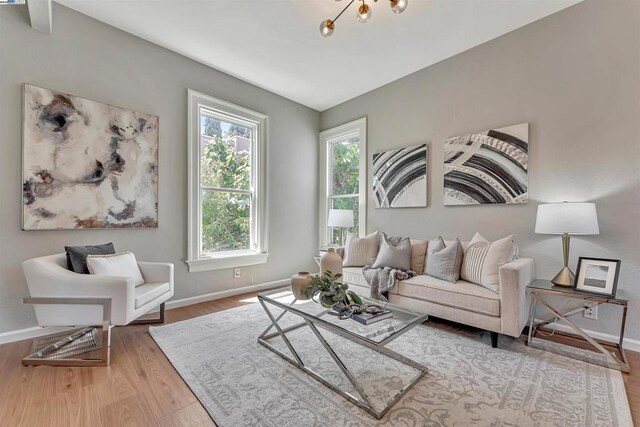 living room featuring an inviting chandelier and hardwood / wood-style floors