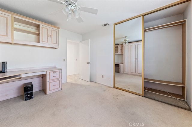 unfurnished office with ceiling fan and light colored carpet