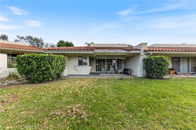 back of property with a patio area and a yard