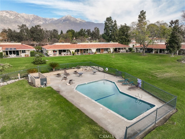 view of pool with a patio area, a mountain view, and a lawn