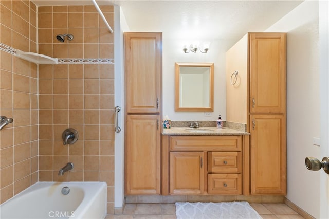 bathroom featuring tile patterned floors, tiled shower / bath combo, and vanity