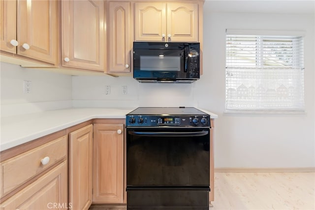 kitchen featuring black appliances, light brown cabinetry, and light hardwood / wood-style floors