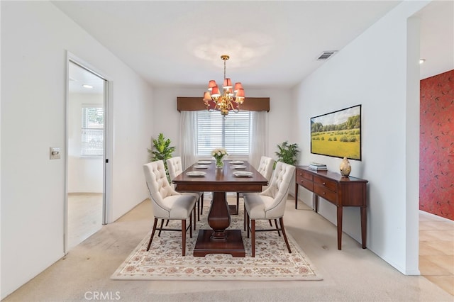 dining area with light carpet and an inviting chandelier