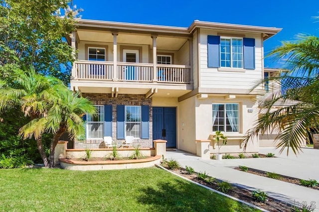 view of front of house featuring a balcony and a front yard