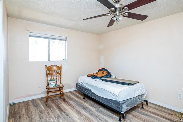 bedroom featuring ceiling fan, a textured ceiling, and hardwood / wood-style flooring