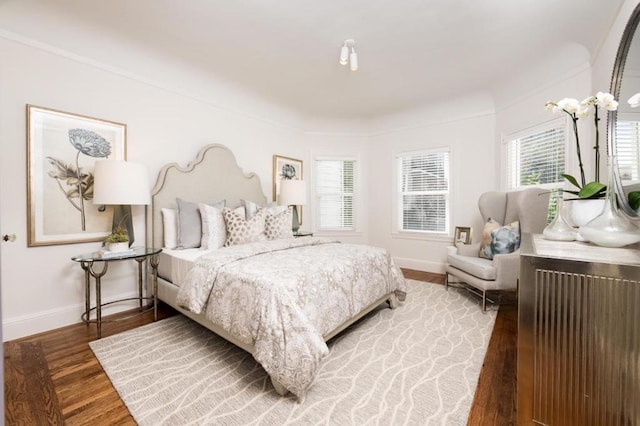 bedroom with hardwood / wood-style flooring and multiple windows