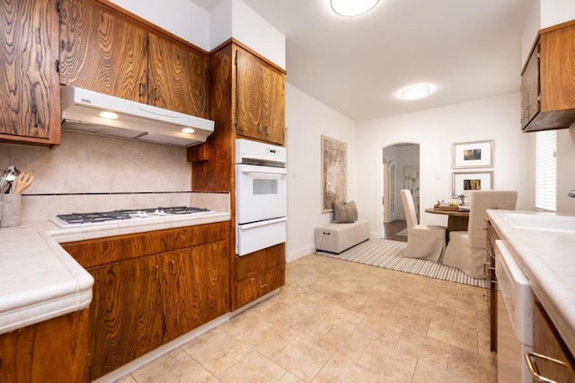 kitchen featuring sink, white appliances, and exhaust hood