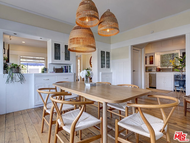 dining area with light hardwood / wood-style flooring and ornamental molding