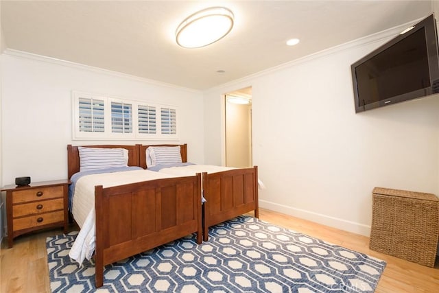 bedroom featuring ornamental molding and light wood-type flooring