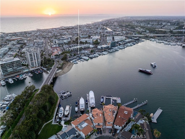 aerial view at dusk featuring a water view